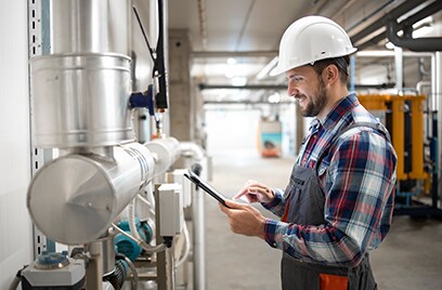 A technician standing near a Sabroe equipment and checking his tablet