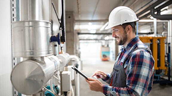 A technician standing near a Sabroe equipment and checking his tablet